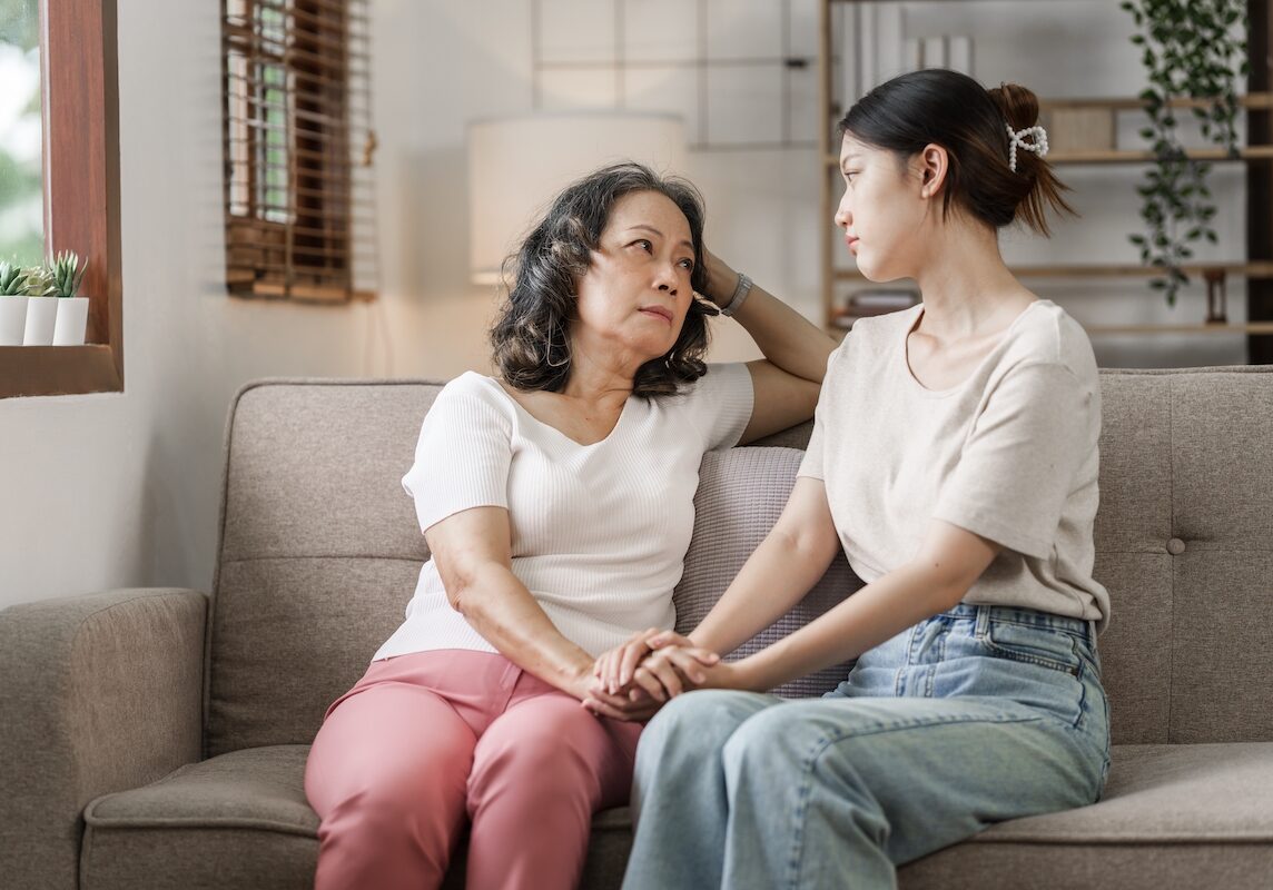 Triste mujer asiática madura, hija adulta o nieto sentado en el sofá abrazando desesperado, mi corazón se calienta ante ti, querida mami.